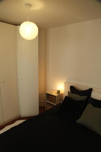 - une chambre avec un lit noir et une lampe dans l'établissement Apparemment cosy île saint louis, à Paris