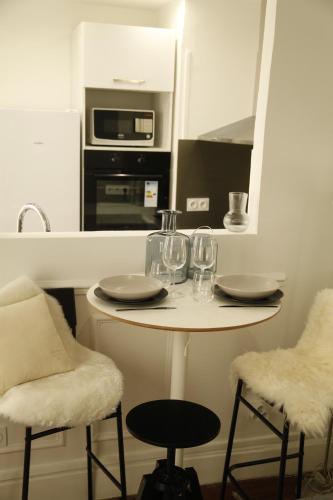 - une petite cuisine avec une table et des verres à vin dans l'établissement Apparemment cosy île saint louis, à Paris
