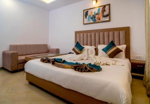 a bedroom with a large bed and a couch at Florence Continental Udaipur in Udaipur
