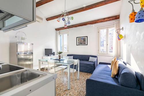 威尼斯的住宿－iHOMES Rialto-Corte del Calice-Attico vista centro，客厅配有蓝色的沙发和桌子