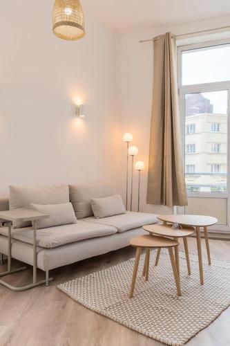 un salon avec un canapé et deux tables dans l'établissement Spacious and bright studio in the center., à Lille