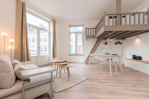 a living room with a couch and a table at Spacious and bright studio in the center. in Lille