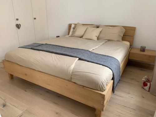 Sonniges und stylishes Bijou in St. Moritz Bad في سان موريتز: سرير كبير مع اطار خشبي في الغرفة