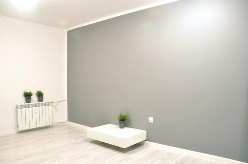 a room with a white table and a gray wall at Nice and comfy studio close to Old town and metro. in Warsaw