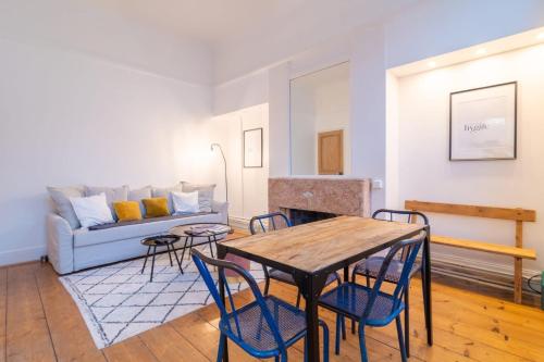 un salon avec une table, des chaises et un canapé dans l'établissement Lille Centre - Nice cozy and functional ap, à Lille
