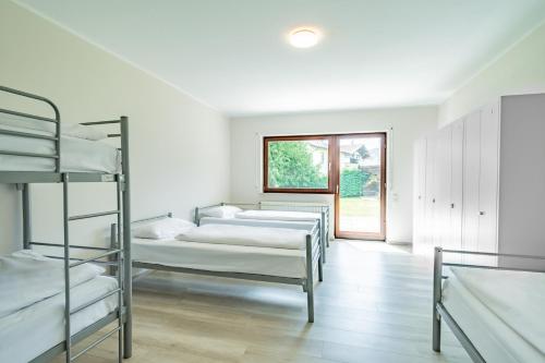 Zimmer mit 3 Etagenbetten und einem Fenster in der Unterkunft Aparthotel Panorama in Bad Soden-Salmünster