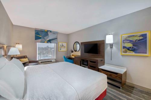 ジャクソンにあるHampton Inn & Suites Jacksonのベッドとデスクが備わるホテルルームです。