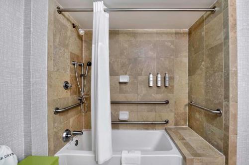 傑克遜的住宿－傑克遜漢普頓套房酒店，浴室配有白色浴缸和淋浴。