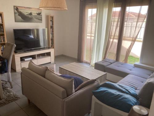 een woonkamer met banken en een flatscreen-tv bij Maison avec piscine 1 chambres 
