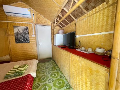 Habitación pequeña con cama y TV. en Wangsarai Resort, en Don Sak
