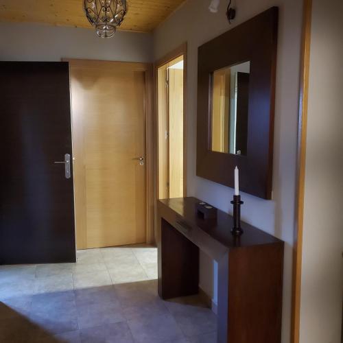 een badkamer met een wastafel, een spiegel en een kaars bij VUT Casa abuela Antonia in El Barco de Ávila