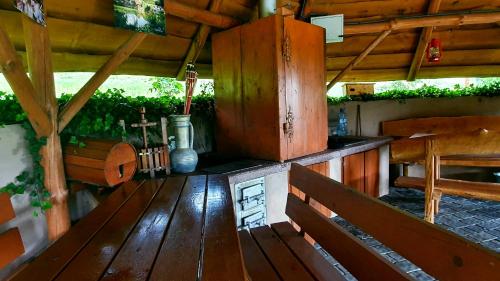 a porch of a wooden cabin with wooden benches at Apartament w Winiarni in Dąbrówka Szczepanowska