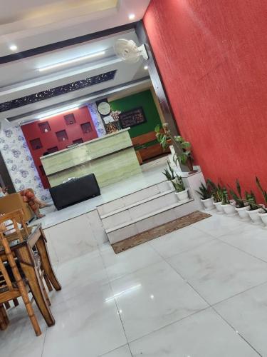 Zimmer mit einer roten Wand, Treppen und Stühlen in der Unterkunft Hotel rose ivyy in Neu-Delhi