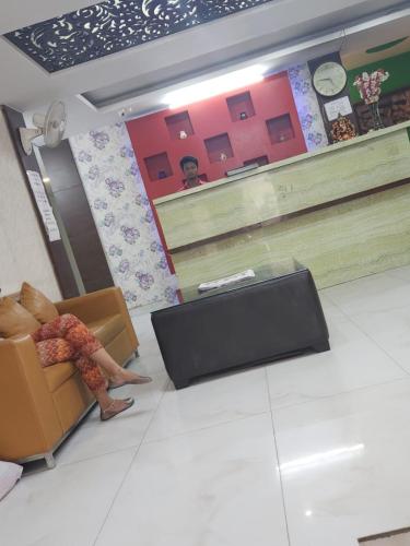 Eine Frau, die auf einem Stuhl im Wartezimmer sitzt. in der Unterkunft Hotel rose ivyy in Neu-Delhi