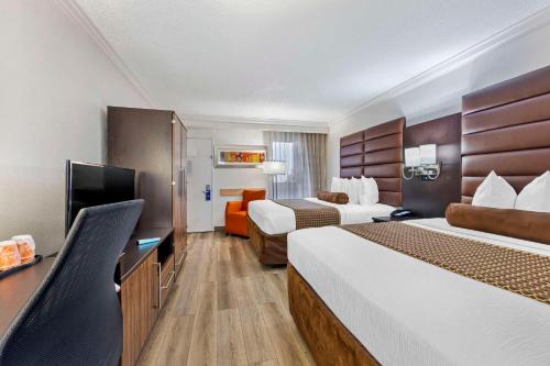 a hotel room with two beds and a flat screen tv at The Capitol Hotel Downtown, Ascend Hotel Collection in Nashville