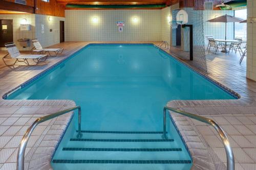 a large swimming pool with stairs in a building at AmericInn by Wyndham New Richmond in New Richmond