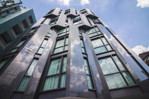 a tall building with glass windows on the side at SureStay Plus by Best Western Sukhumvit 2 in Bangkok