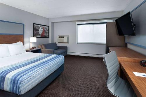a hotel room with a bed and a desk at AmericInn by Wyndham New Richmond in New Richmond