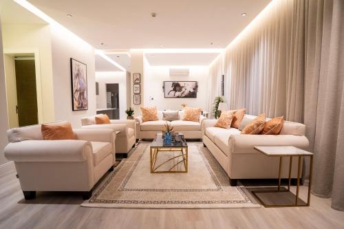 Riyadh Comfort Stay - Luxury الملقا Almalqa, 3 Bedrooms في الرياض: غرفة معيشة مع كنب ابيض وطاولة