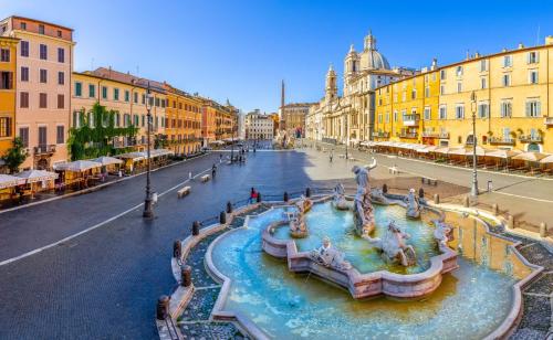 uma fonte no meio de uma rua com edifícios em The Point Suites Rome - Guest House em Roma