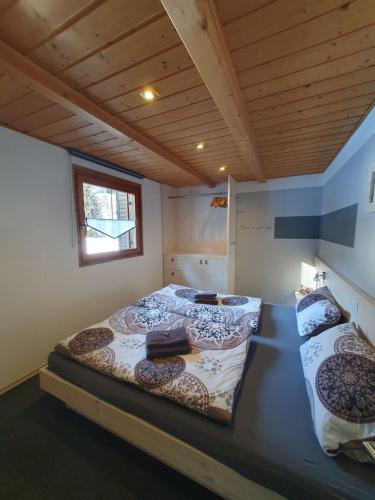 1 Schlafzimmer mit 2 Betten in einem Zimmer mit Holzdecke in der Unterkunft Haus Idili in Sankt Gallenkirch