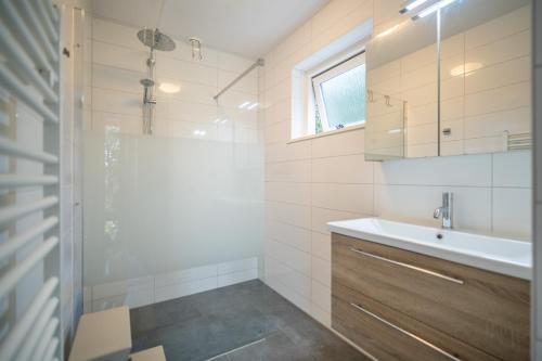 a bathroom with a shower and a sink at Nieuwlanderweg 51 in De Waal