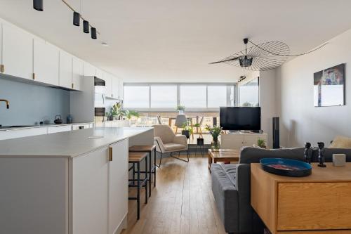 Il dispose d'une cuisine ouverte et d'un salon avec un canapé et une table. dans l'établissement Veeve - Riverside Heights, à Paris