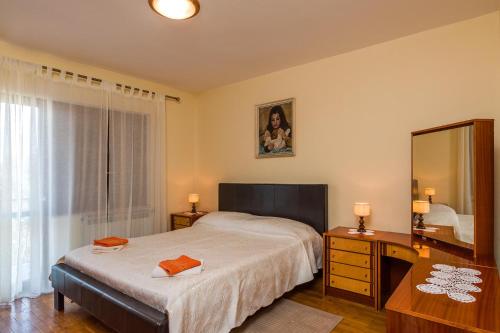 een slaapkamer met een bed, een bureau en een spiegel bij Apartment Nada 1202 in Banjole