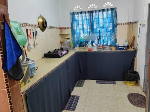 a kitchen with a counter and a blue counter top at Comfort Stay Kuala Perlis Wi-Fi Nexflix in Kuala Perlis