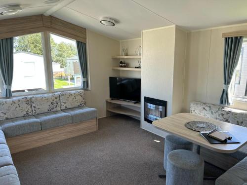 a living room with a couch and a tv at McCanns Caravan Marton Mere in Blackpool