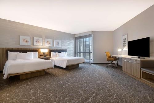 a hotel room with two beds and a flat screen tv at Hilton Garden Inn Anaheim Resort in Anaheim