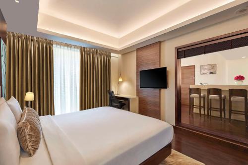 a hotel room with a bed and a television at DoubleTree by Hilton Gurugram Baani Square in Gurgaon