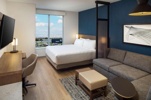 a hotel room with a bed and a couch at Hyatt Place Boise-Meridian in Meridian