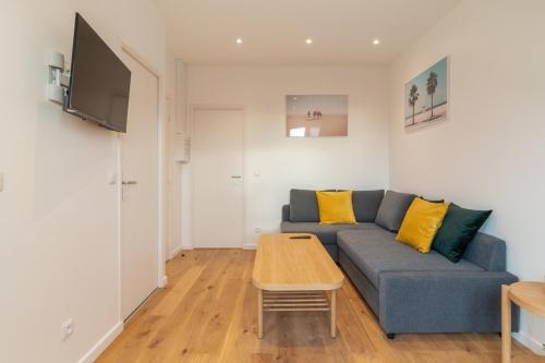 un salon avec un canapé bleu et une table dans l'établissement Lille Centre - Nice cozy and functional ap, à Lille