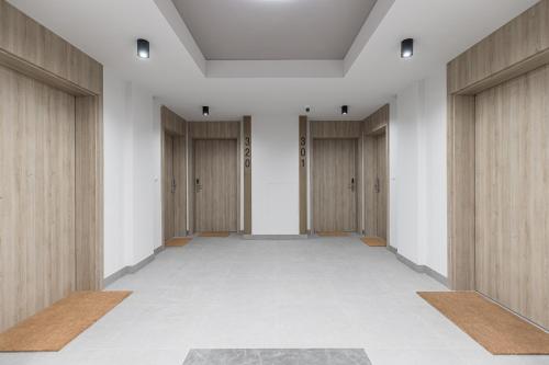 an empty corridor with wooden doors in a building at Otyńska Point Apartamenty Prestige in Wrocław