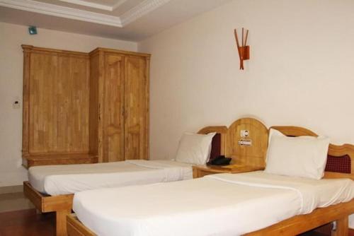 a bedroom with two beds and wooden cabinets at HOTEL SKY PARK in Mattanūr