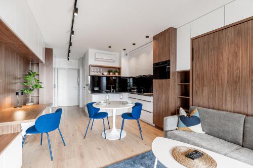 a living room with a couch and a table and chairs at Otyńska Point Apartamenty Prestige in Wrocław