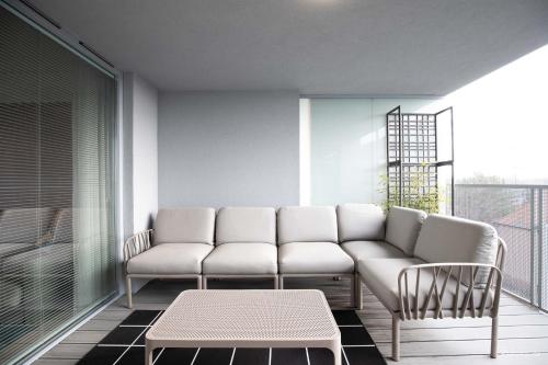 a living room with a couch and chairs on a balcony at Otyńska Point Apartamenty Prestige in Wrocław