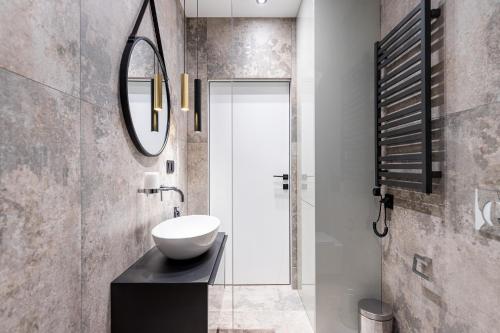 a bathroom with a sink and a mirror at Otyńska Point Apartamenty Prestige in Wrocław