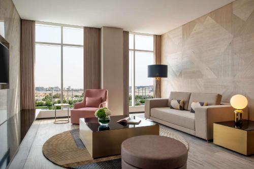 Rixos Gulf Hotel Doha في الدوحة: غرفة معيشة مع أريكة وطاولة
