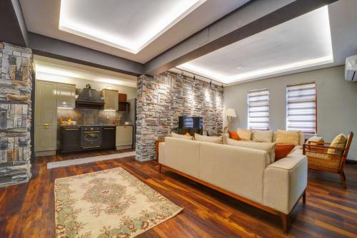 a living room with a couch and a stone wall at Kerem ile Aslı Butik Hotel in Melikgazi
