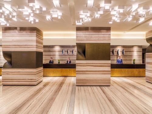 a rendering of a lobby with wood dividers at Rixos Gulf Hotel Doha in Doha