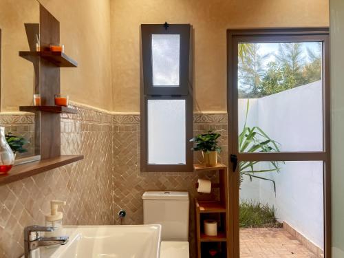 ein Bad mit einem WC und einem Fenster in der Unterkunft Villa Tremoulet Swimming pool & Breakfast in Essaouira
