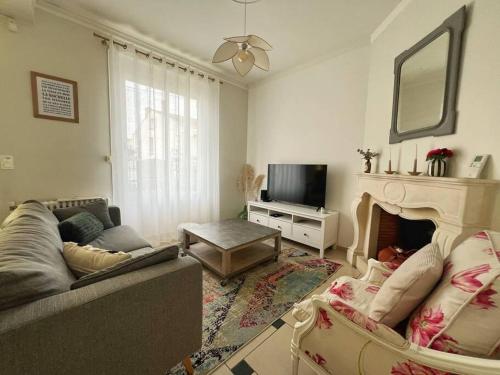 a living room with a couch and a fireplace at L'idylle - Maison & Terrasse in La Rochelle