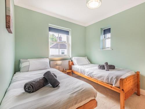 2 camas en una habitación con 2 ventanas en 3 Bed in Christchurch 73946, en Christchurch