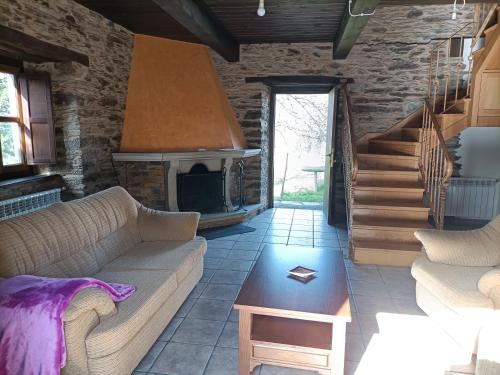 a living room with a couch and a fireplace at CASA DA RIBEIRA in Quiroga