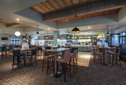 um restaurante com mesas e cadeiras num quarto em The Saxon Crown Wetherspoon em Corby