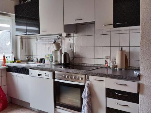 een keuken met witte apparaten en zwarte aanrechtbladen bij Spatzenbergzimmer 2 in Obersulm