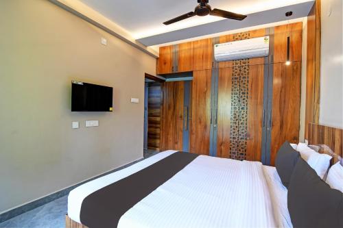 a bedroom with a bed and a flat screen tv at OYO Flagship Welcome Premium in Khandagiri