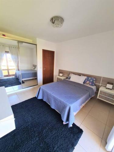 1 dormitorio con cama azul y espejo en Pacotes Carnaval - Sobrado perto MAR en Capão da Canoa